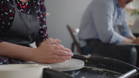 Close-up-of-the-hand-of-a-grumpy-woman-master-works-on-a-potter's-wheel-in-slow-motion.-Making-utensils-with-your-own-hands